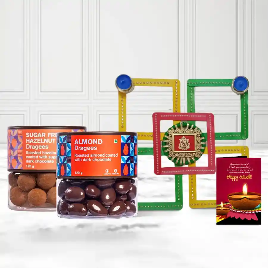 Hazelnut and almond dragees in colorful packaging with a decorative candle diya and rangoli design, accompanied by a Diwali greeting card.