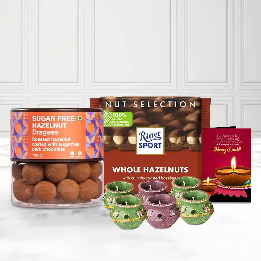 Munching Delight Sugar-Free Hazelnut Dragee gift basket with hazelnut dragees, Ritter Sports Whole Hazelnut Bar, wax diyas, and Diwali card