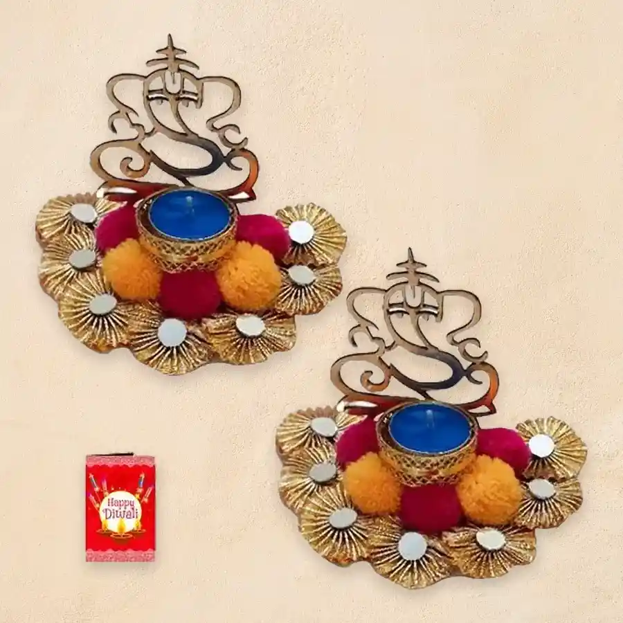 Projecting Ganesh Light Diya Set with vibrant pom-poms, sparkling mirrors, and intricate zardosi detailing, glowing warmly in a festive setting