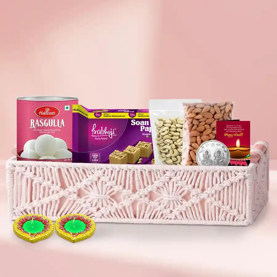 Diwali hamper featuring sweets, dry fruits, Ganesh-Laxmi coin, and designer diyas in a gift basket
