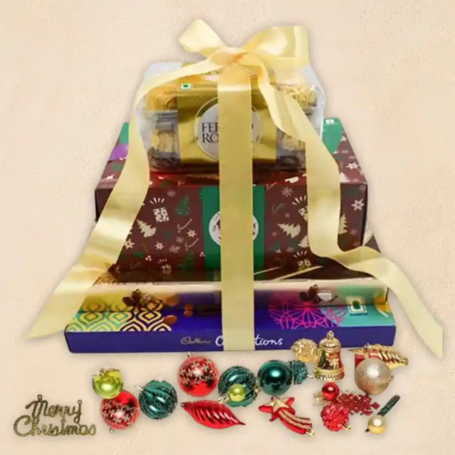 Delectable Chocolate Tower Gift with Xmas decorations, featuring layers of rich American Fruit Cake, Ferrero Rocher Moments, assorted Cadbury Celebrations, and Ferrero Hazelnut Chocolates, accompanied by a charming box of Christmas decorations.