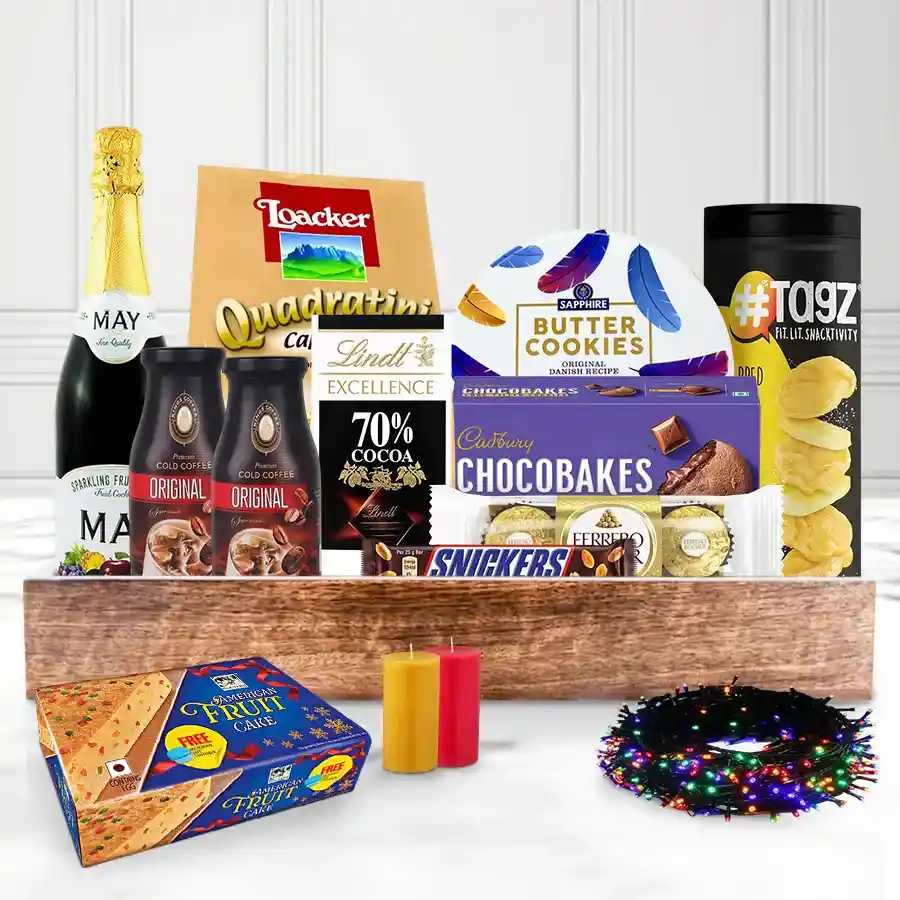 Ultimate Munch-in Magic Christmas Basket filled with festive treats including sparkling fruit juice, chocolate, snacks, cookies, and decorative candles, arranged in a reusable basket.