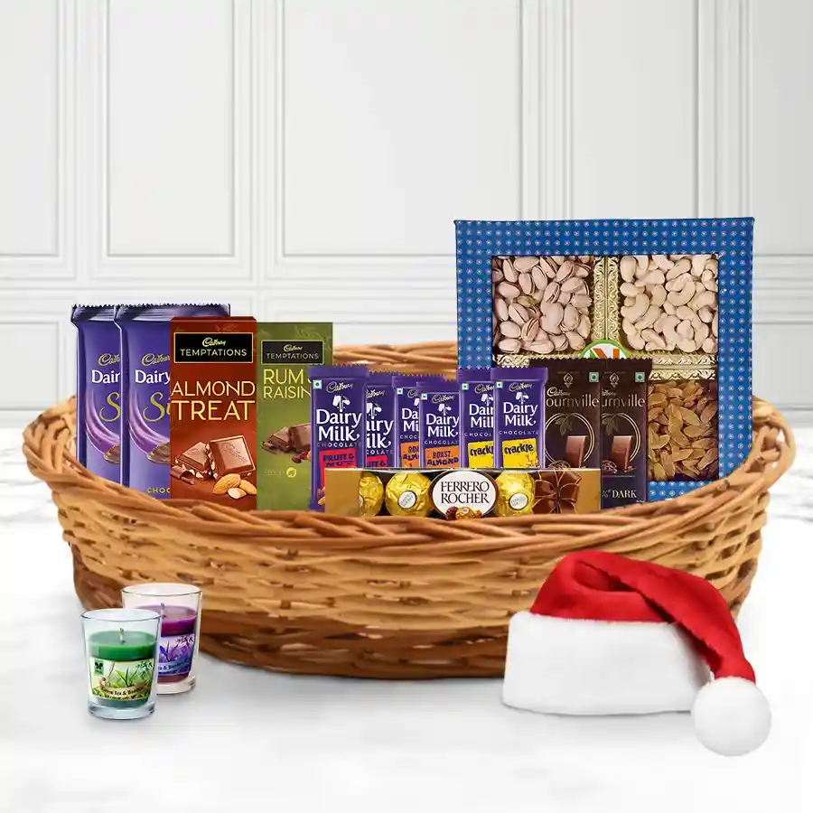 Chocolaty Blast X-Mas Supreme Basket filled with assorted chocolates, dry fruits, a candle, and a Santa cap, beautifully arranged in a reusable gift basket.