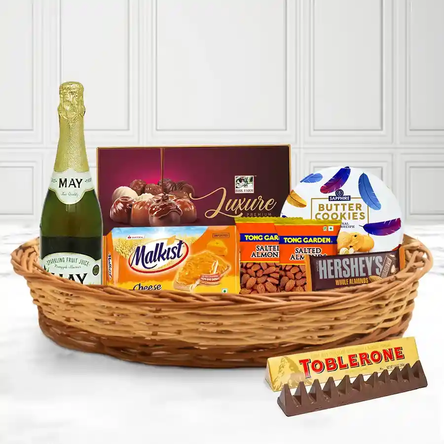 Gift basket filled with festive snacks including chocolates, juice, cookies, almonds, and crackers, elegantly arranged for Christmas celebrations.
