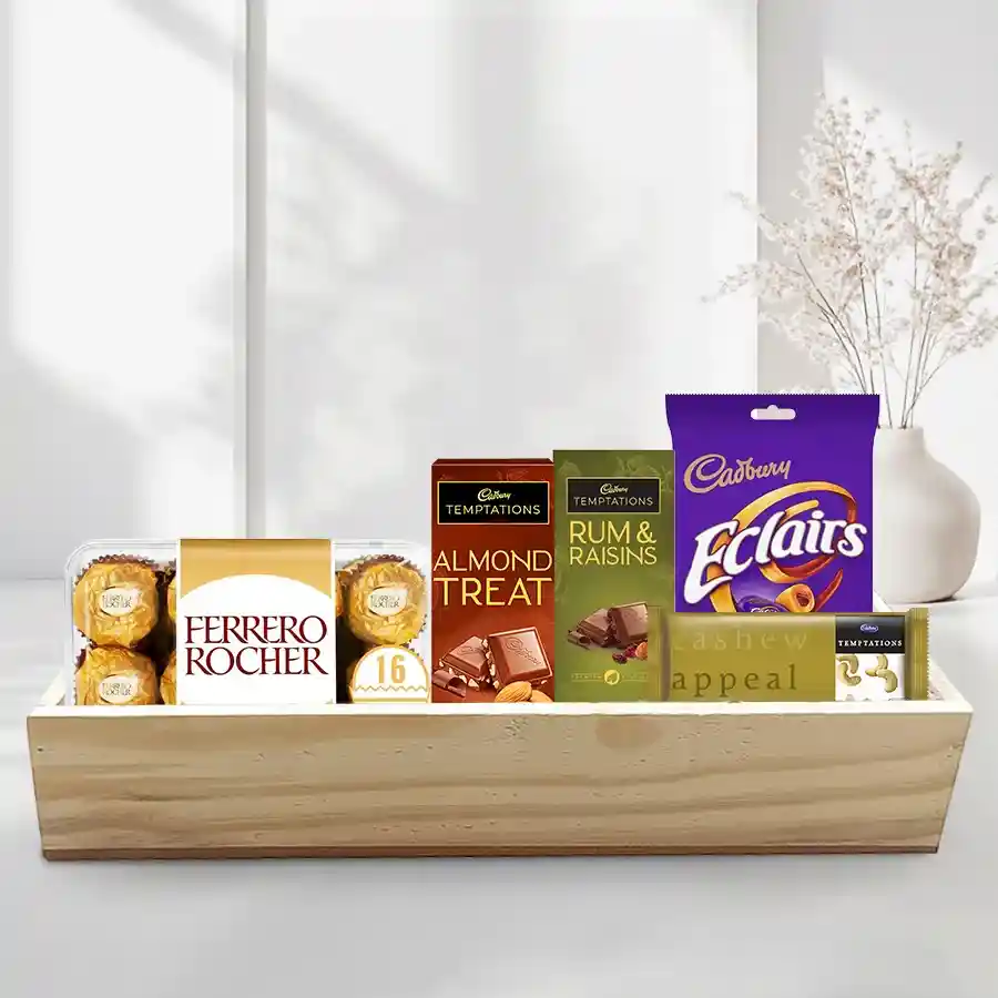 Absolute Indulgence Chocolate Tray featuring Ferrero Rocher chocolates, Cadbury Temptation bars in Rum & Raisins, Cashew, and Almond flavors, and Cadbury Eclairs arranged on a stylish wooden tray for Christmas.