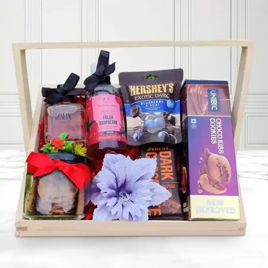 Sensational Gift Basket for Women featuring Body Shop Shower Gel, Zara Perfume, crunchy cookies, Amul Dark Chocolate, Hershey’s Blueberry & Acai bites, UNIBIC Chocokiss Cookies, all arranged in a reusable wooden basket.