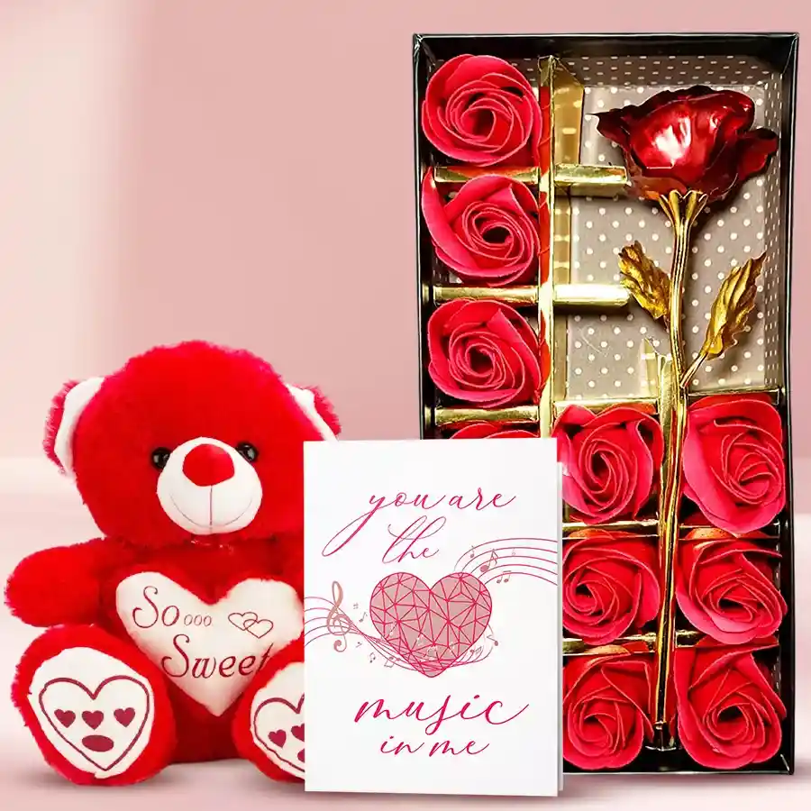 Ravishing Rosy Box featuring an artificial red rose, a pink singing teddy bear, and musical greeting cards arranged in an elegant presentation