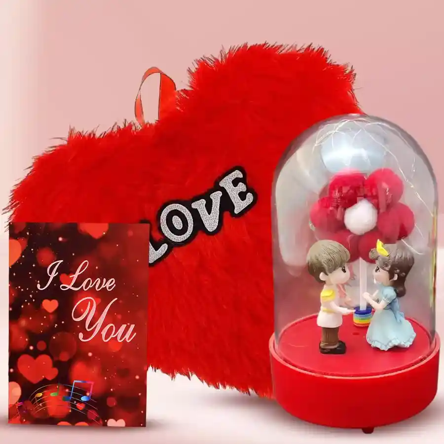 Couple glass bottle showpiece with LED light, love cushion, and musical greetings card arranged in a romantic setting.