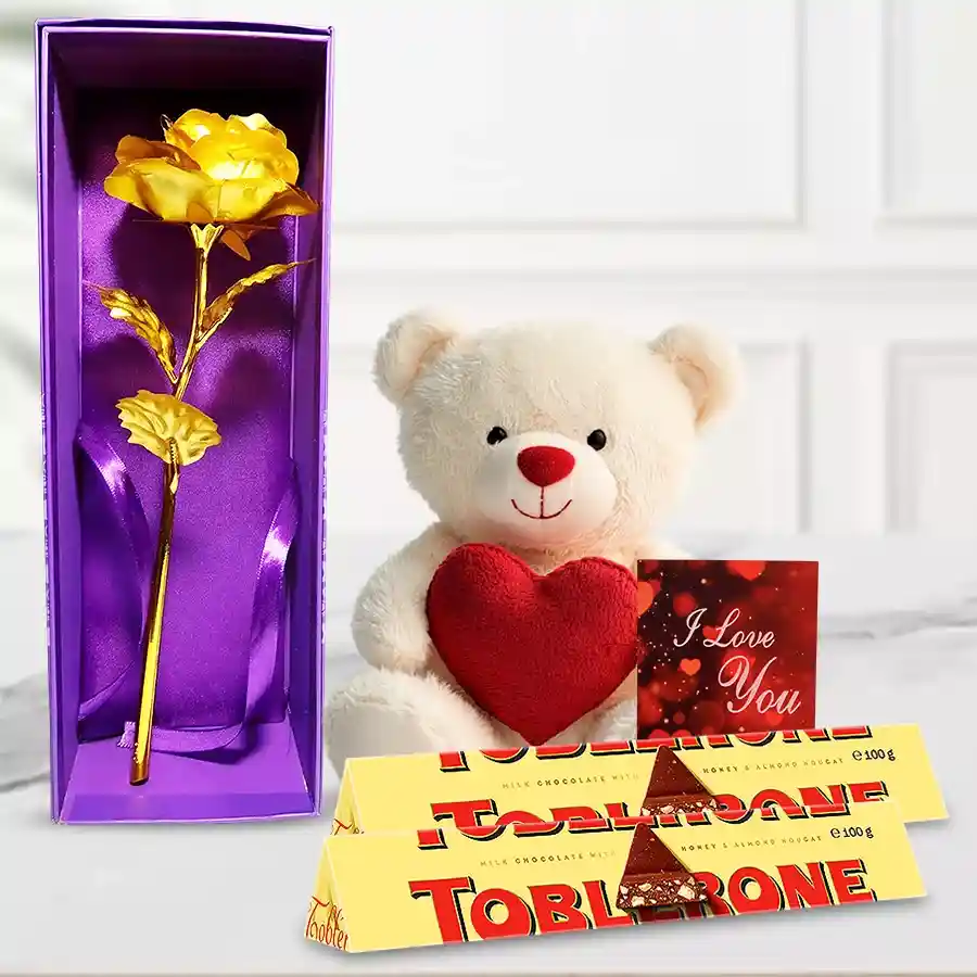 Special Teddy Day Gift Trio featuring a cream teddy bear with a heart, two Toblerone bars, a golden rose, and an "I Love You" card
