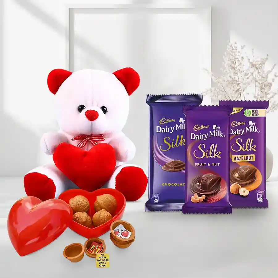 Valentine's Day combo featuring a 6-inch red and white teddy bear holding a heart, a personalized heart-shaped message box, and an assortment of Cadbury Dairy Milk Silk chocolates.