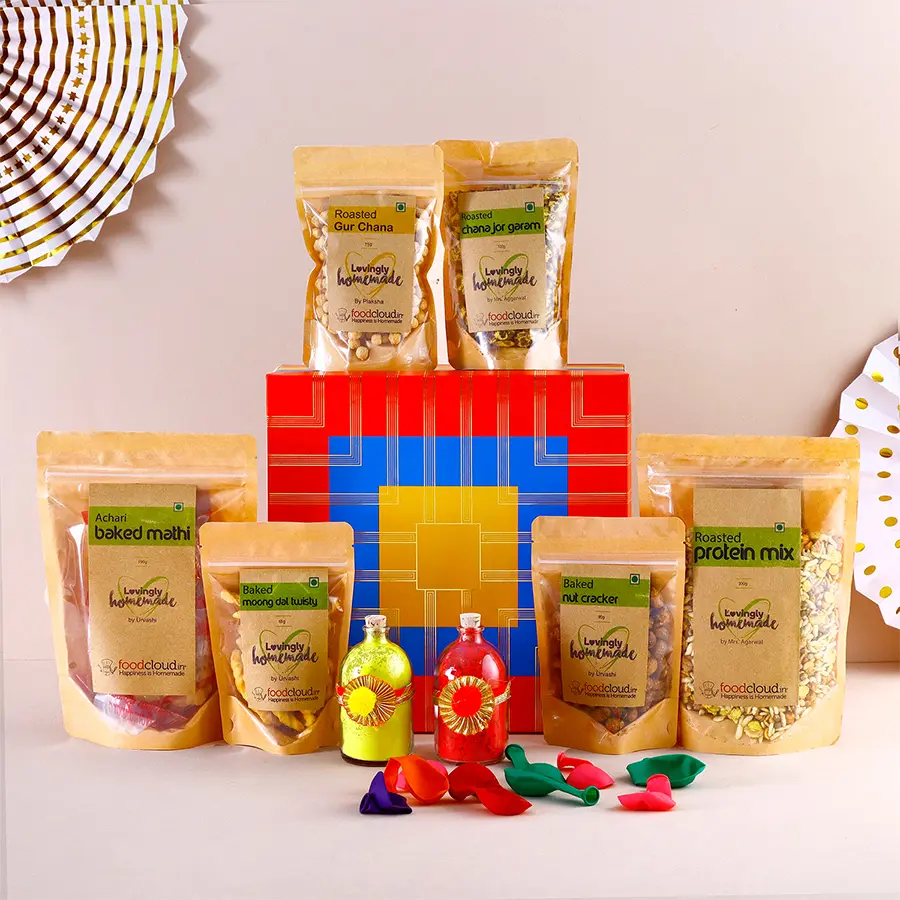 Special Baked N Roasted Treats Combo for Holi featuring snacks like Baked Methi Mathi, Moong Dal Twisty, Roasted Mix, Gur Chana, Gur Peanut Chikki, and a jar of organic Gulal