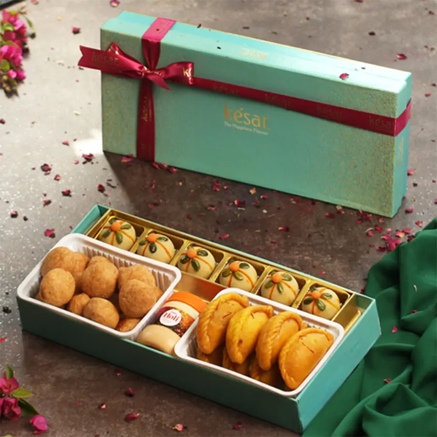 Flavorful Sweets with Kachori N Chandan Gift Box featuring Badam Thandai Ladoos, Kesar Gujiyas, Mini Kachoris, Chandan bottle, and Holi greeting card in a festive packaging.