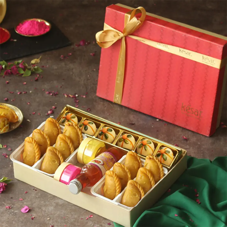 Sweetlicious Treat with Chandan N Gulal Gift Combo featuring Badam Thandai Ladoos, Kesar Gujiya, Chandan, Gulal, and a Holi greetings card beautifully packaged in a festive box.