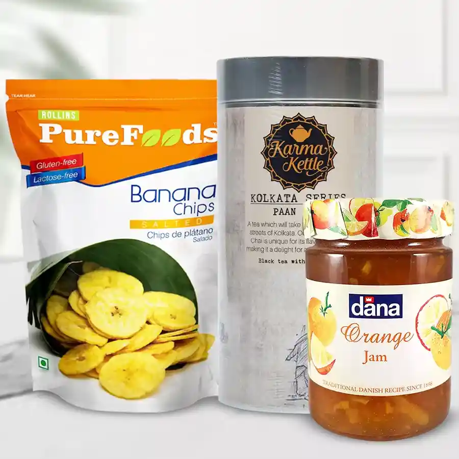 Crunchy Banana Chips with Karma Kettle Paan Cha and Dana Jam gift bundle displayed on a wooden surface