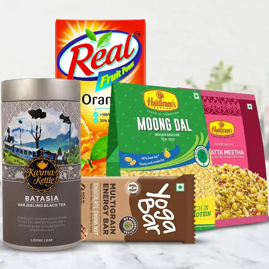 Remarkable hamper featuring Batasia Tea, Haldiram savories, and juice, including Karma Kettle Batasia Tea, Yoga Bars, Moong Dal, and Khatta Meetha Mixture.