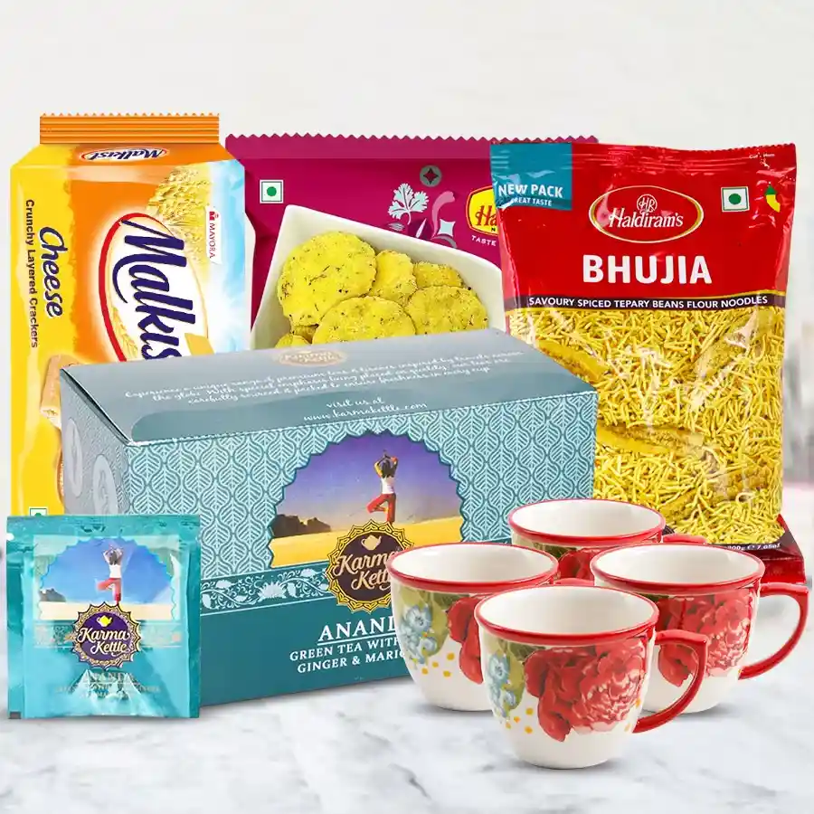 Premium Karma Kettle Ananda Tea Gift Set with tea bags, Haldiram snacks, Malkist Crackers, and a 4-piece cup set