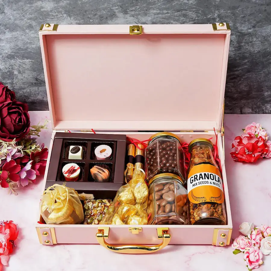 Delicious Goodies Trunk filled with assorted chocolates, almond florentines, chocolate logs, and crunchy granola, presented in a beautiful gift trunk for Mother's Day.