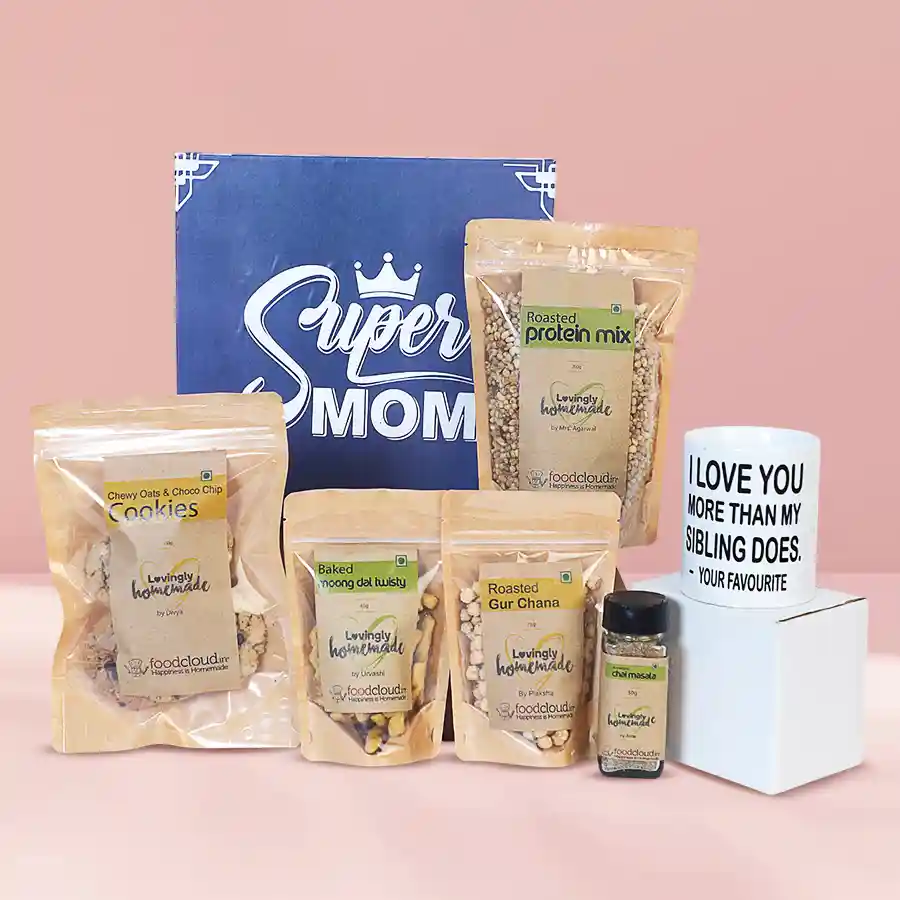 Wholesome box of healthy treats for mom featuring a mug, cookies, moong dal twists, protein mix, and chai masala