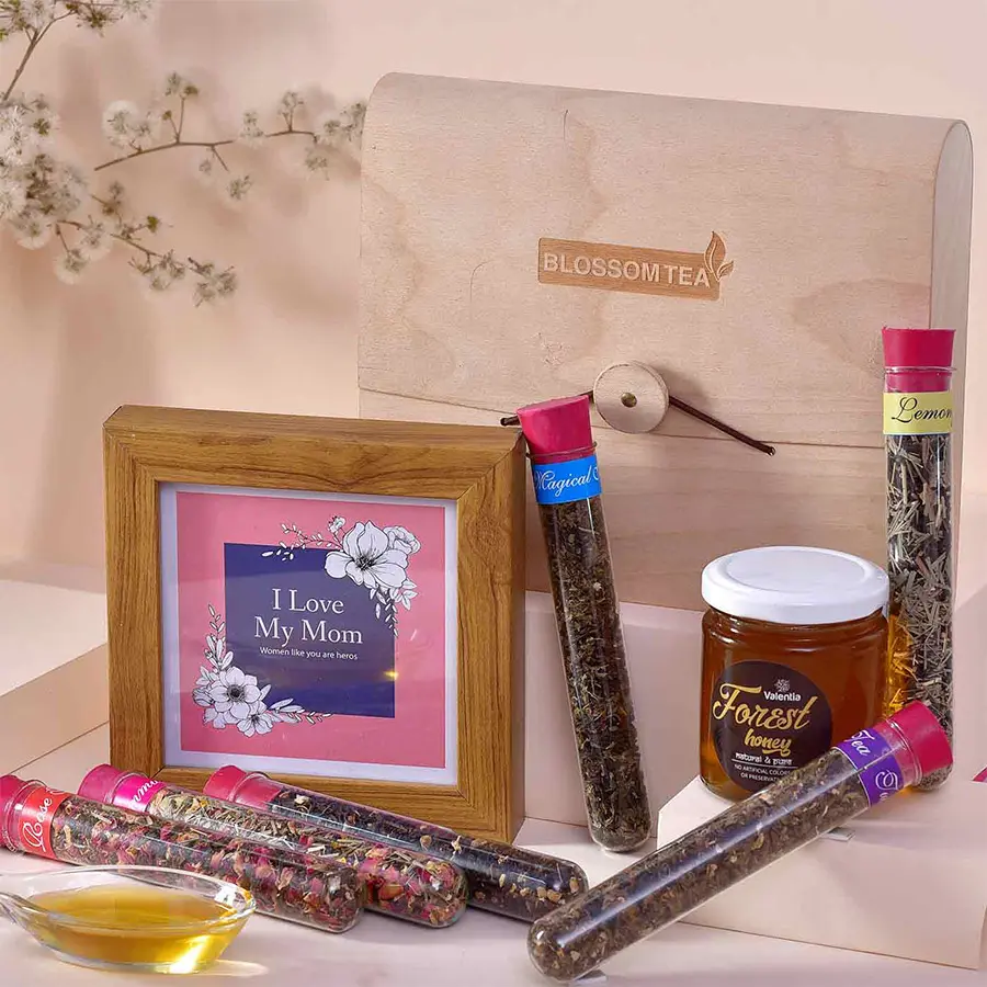 Beautiful Moms Tea Treat Combo featuring a MOM Loving Photo Frame, Valentia Forest Honey jar, and a set of Blossom Tea Wooden Purses.