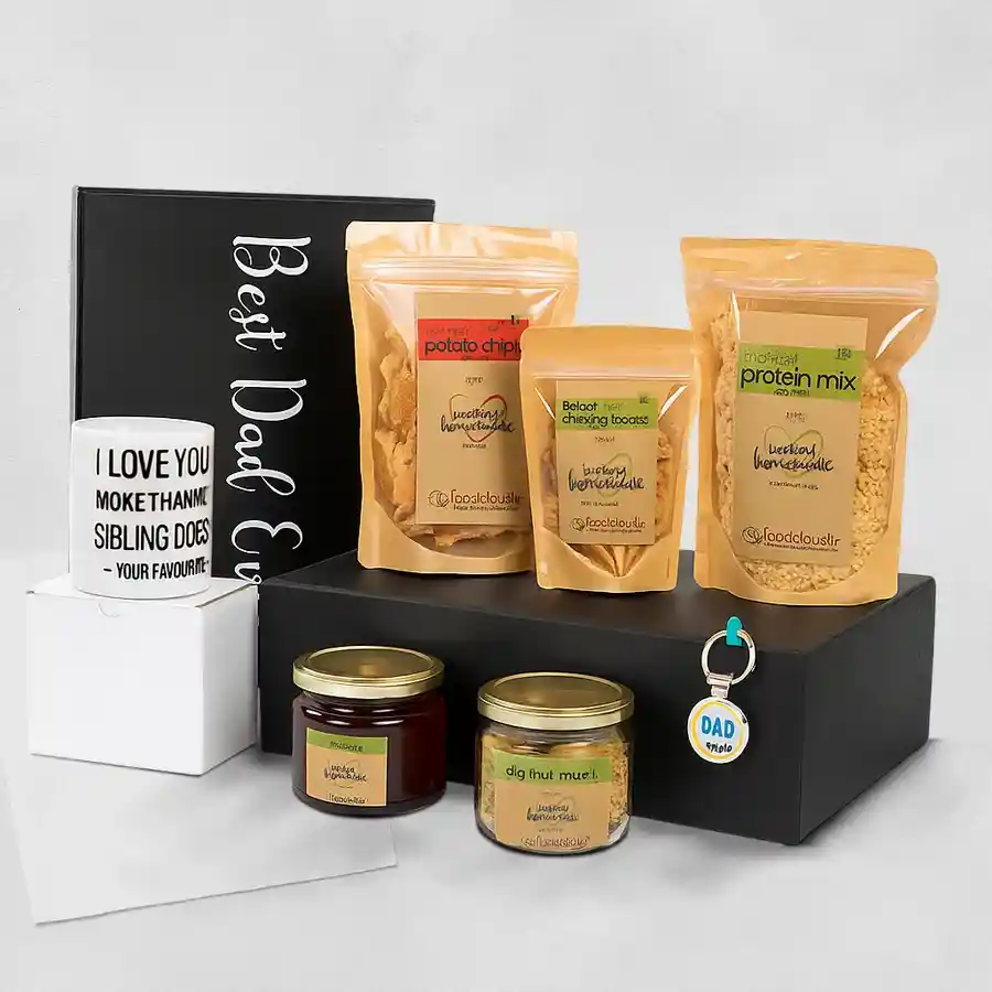 Delish Father's Day Treats Hamper featuring a mug, keychain, dry fruit muesli, natural honey, baked moong dal twisties, potato chips, and roasted protein mix