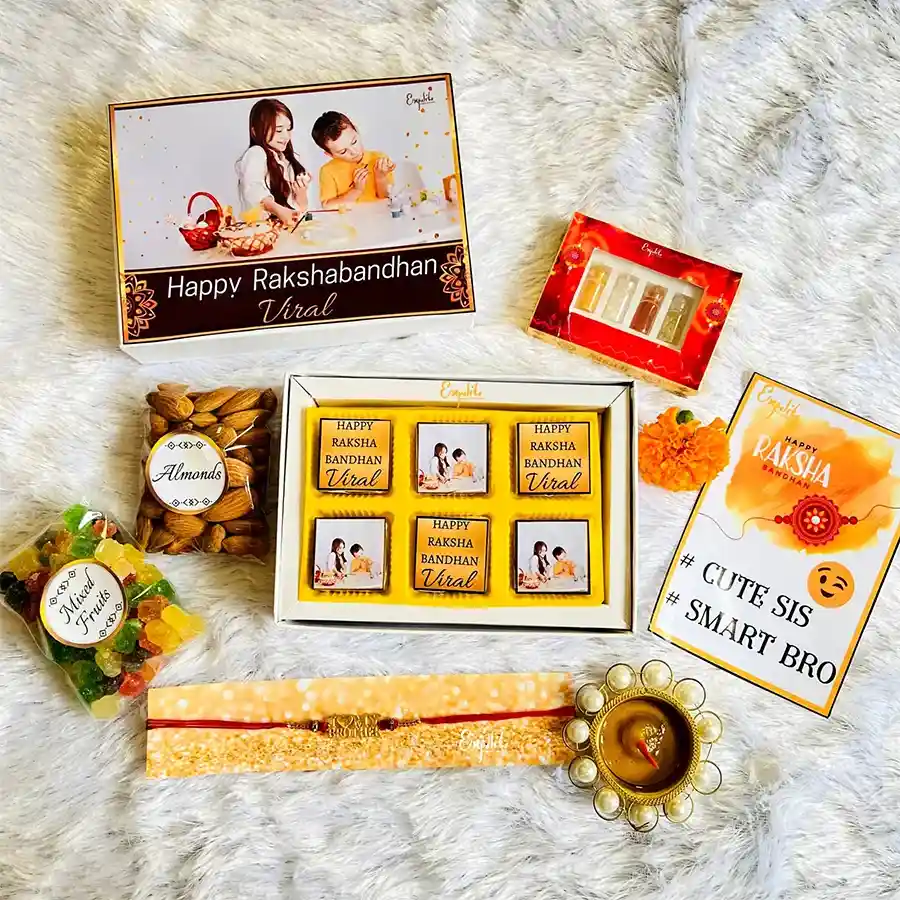 Personalized Rakhi and treat hamper featuring a premium metal Rakhi with colorful beads, assorted chocolates, crunchy almonds, sweet mixed fruits, traditional roli tikka and chandan, along with a personalized box and greeting card.