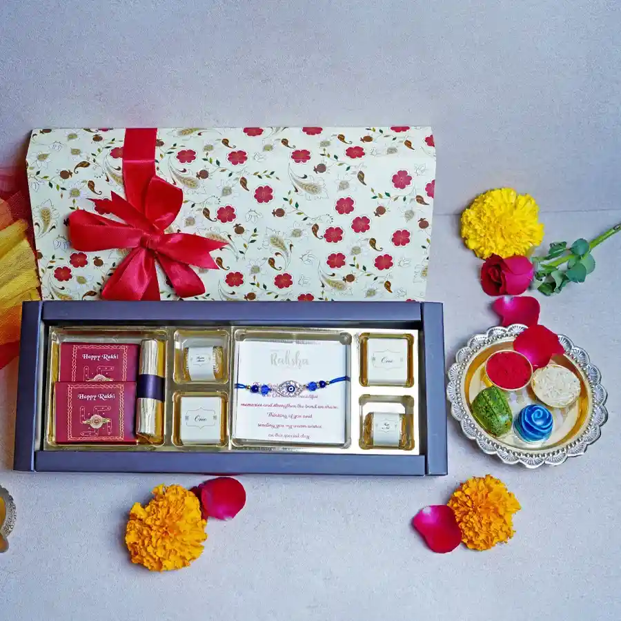 Delightful Chocolate Box for Raksha Bandhan with chocolate bars, orange crisp log, assorted sweet treats, Rakhi, and heartfelt card