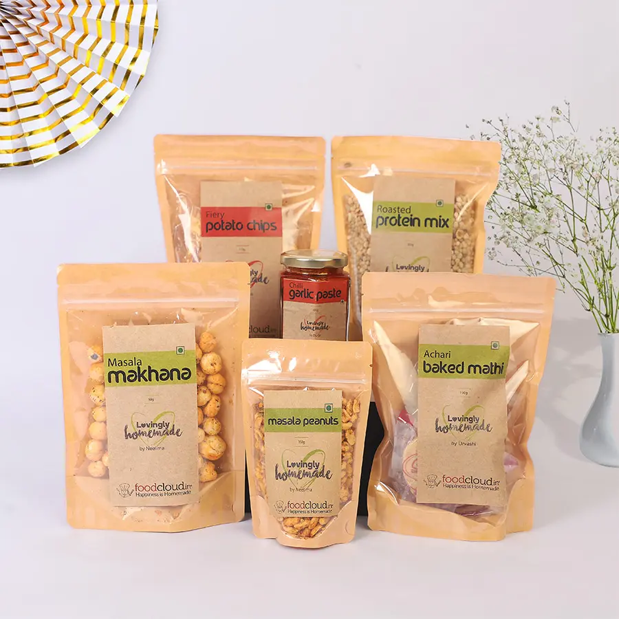Hot N Spicy Food Hamper featuring Chilli Garlic Paste, Fiery Potato Chips, Masala Makhana, Baked Achari Mathi, Masala Peanuts, and Roasted Protein Mix.