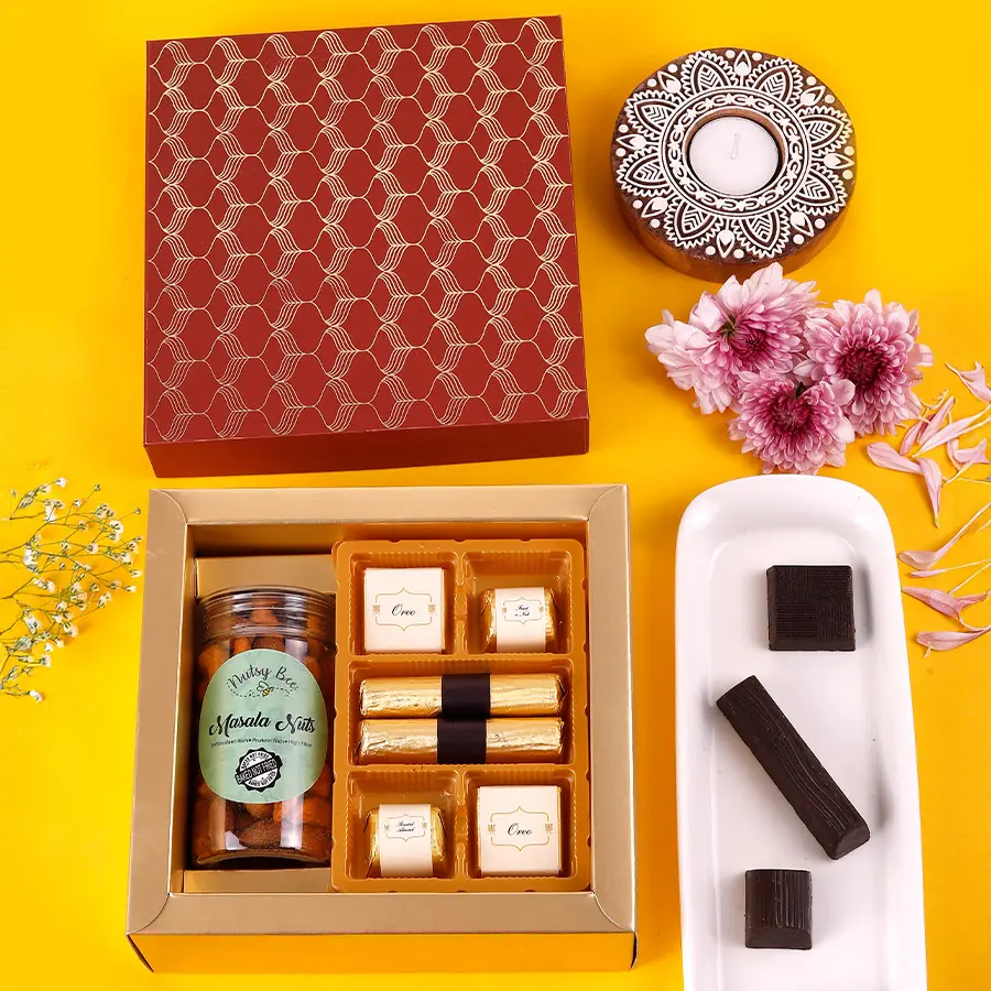 A colorful assortment of chocolates, nuts, and granola bars arranged in a decorative box