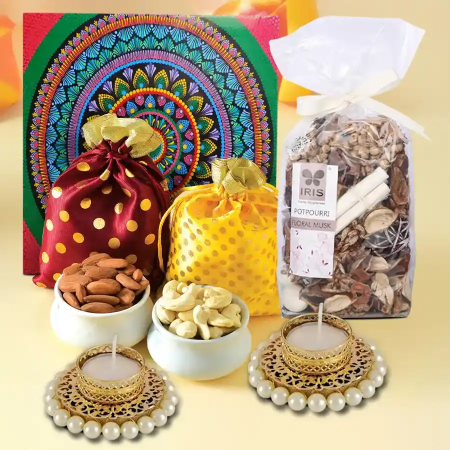 A beautifully arranged Festive Flavors Gift Collection in a reusable mandala box featuring potlis of premium cashews and almonds, Ferrero Rocher chocolates, Iris Potpourri Floral Musk, and pearl T-light candles, all set against a festive backdrop.