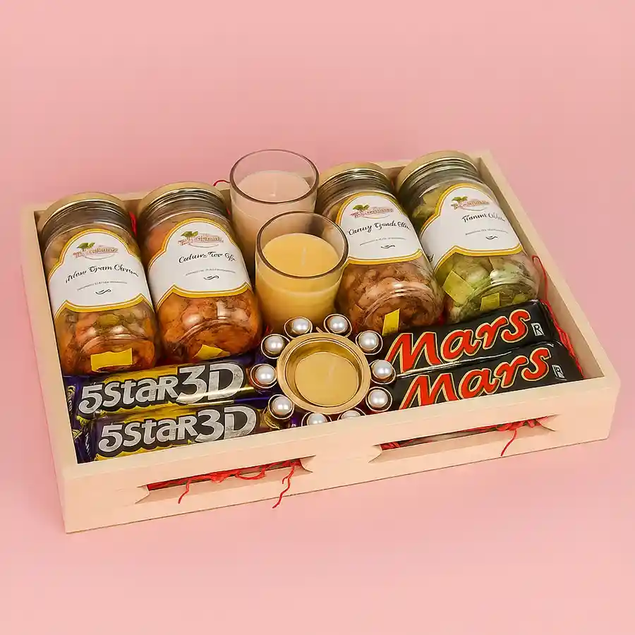 Designer wooden tray filled with assorted treats including Cashew Green Chutney, Peri Peri, Kismis Orange Chilly, Pan Flavored jars, Iris scented candles, a Pearl T Light candle, and sweet 3D 5 Star and Mars chocolates, elegantly presented for Diwali.