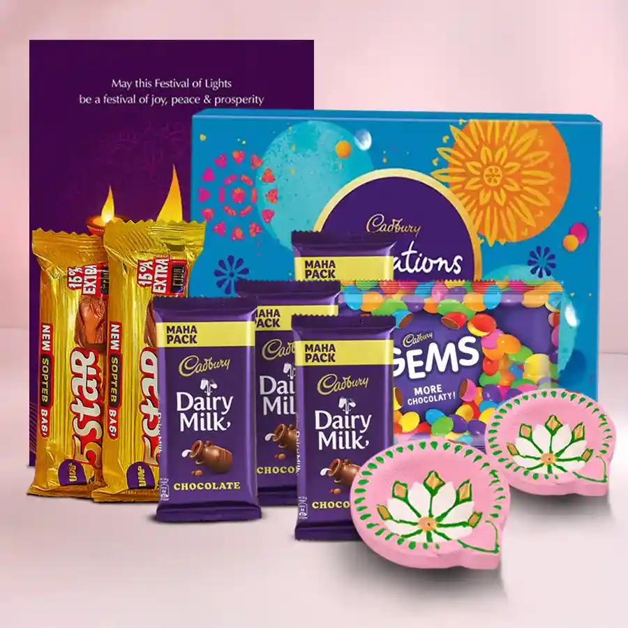 A decorative box filled with assorted Cadbury chocolates, accompanied by two handcrafted clay diyas and a Happy Diwali card, set against a festive background.