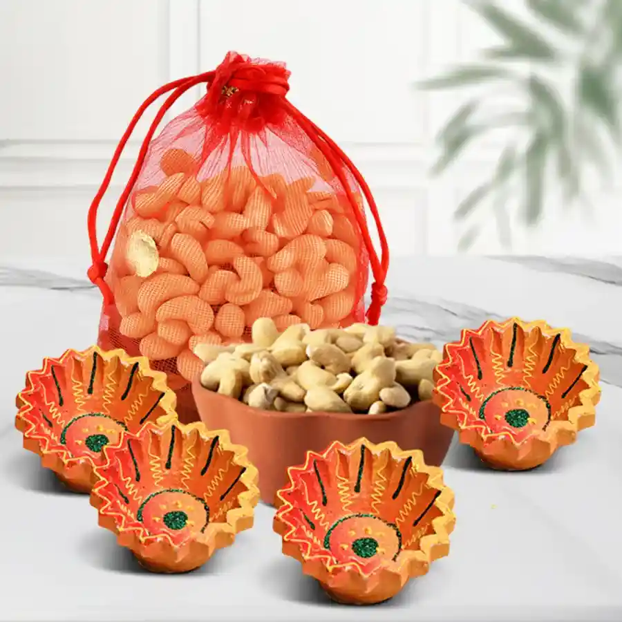 Basket filled with premium cashews in a net potli and four handcrafted clay diyas, symbolizing Diwali celebrations.