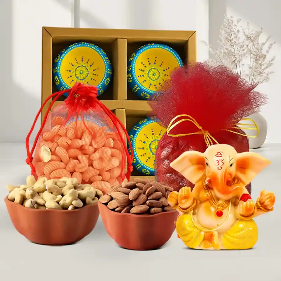 Diwali hamper featuring a Vignesh Ganesh idol, designer net potlis with cashews and almonds, and clay diyas arranged in a festive display.