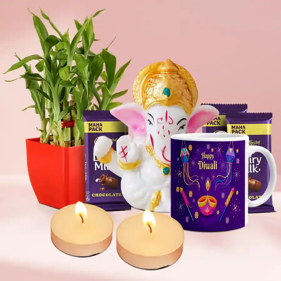 Illuminating Moments Diwali Gift Set featuring a Mukut Ganesh idol, lucky bamboo plant, ceramic mug, Cadbury Dairy Milk chocolates, and scented T-light candles arranged beautifully for a festive celebration.