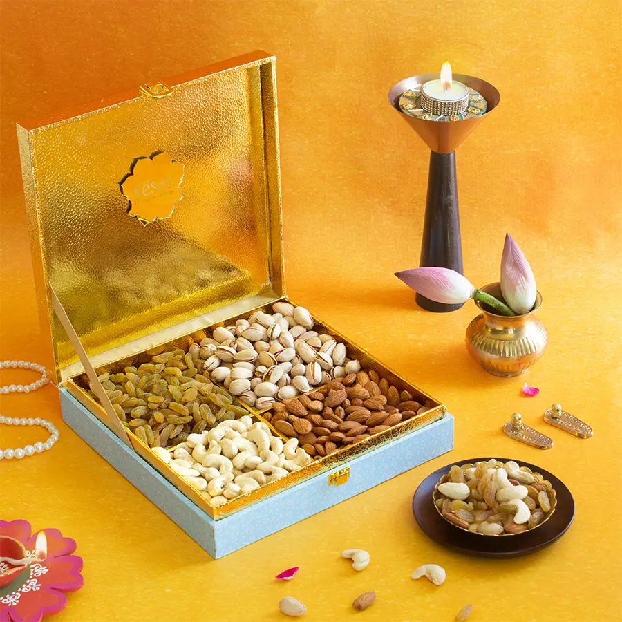 Colorful gift box filled with assorted nuts including almonds, cashews, raisins, and pistachios, decorated for Diwali celebrations.