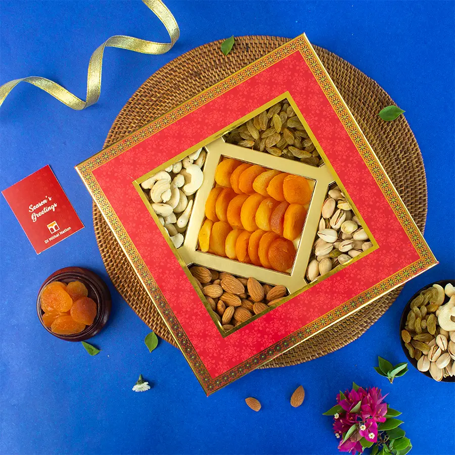 Elegant Dried Fruit Collection Box featuring creamy cashews, crunchy almonds, roasted pistachios, sweet apricots, and juicy raisins in a red and blue window box with a festive greeting card.