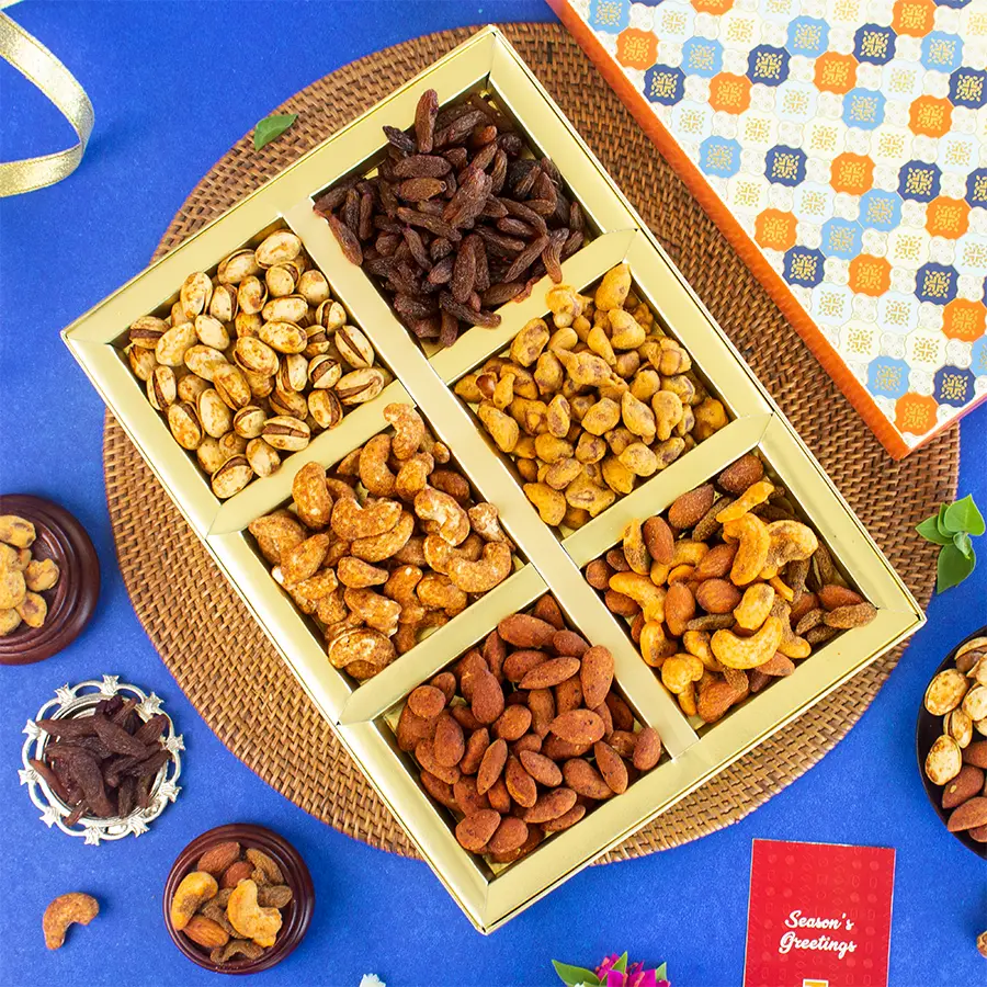 Gift box filled with an assortment of flavored snacks including spicy peri peri cashews, smoky barbeque almonds, zesty masala garlic pistachios, sweet shahi paan raisins, crunchy panchartna mixture, and tangy masala peanuts, accompanied by a festive greeting card.