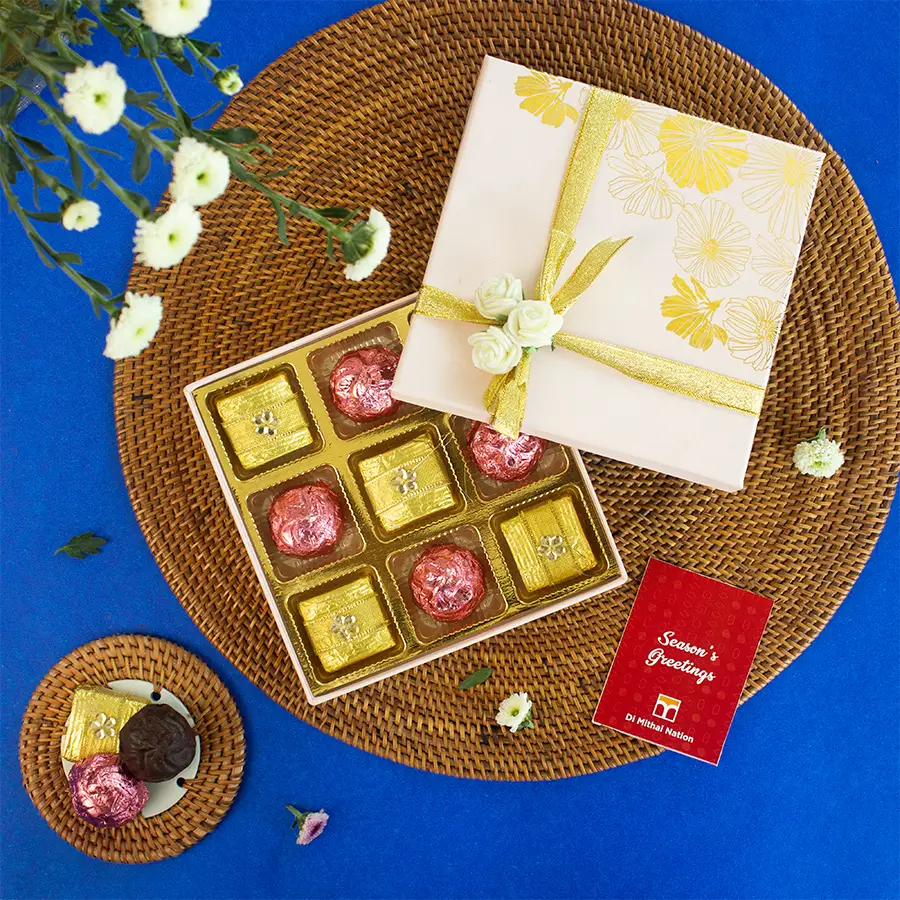 A beautifully packaged pink box containing an assortment of 9 premium handmade chocolates in various flavors.