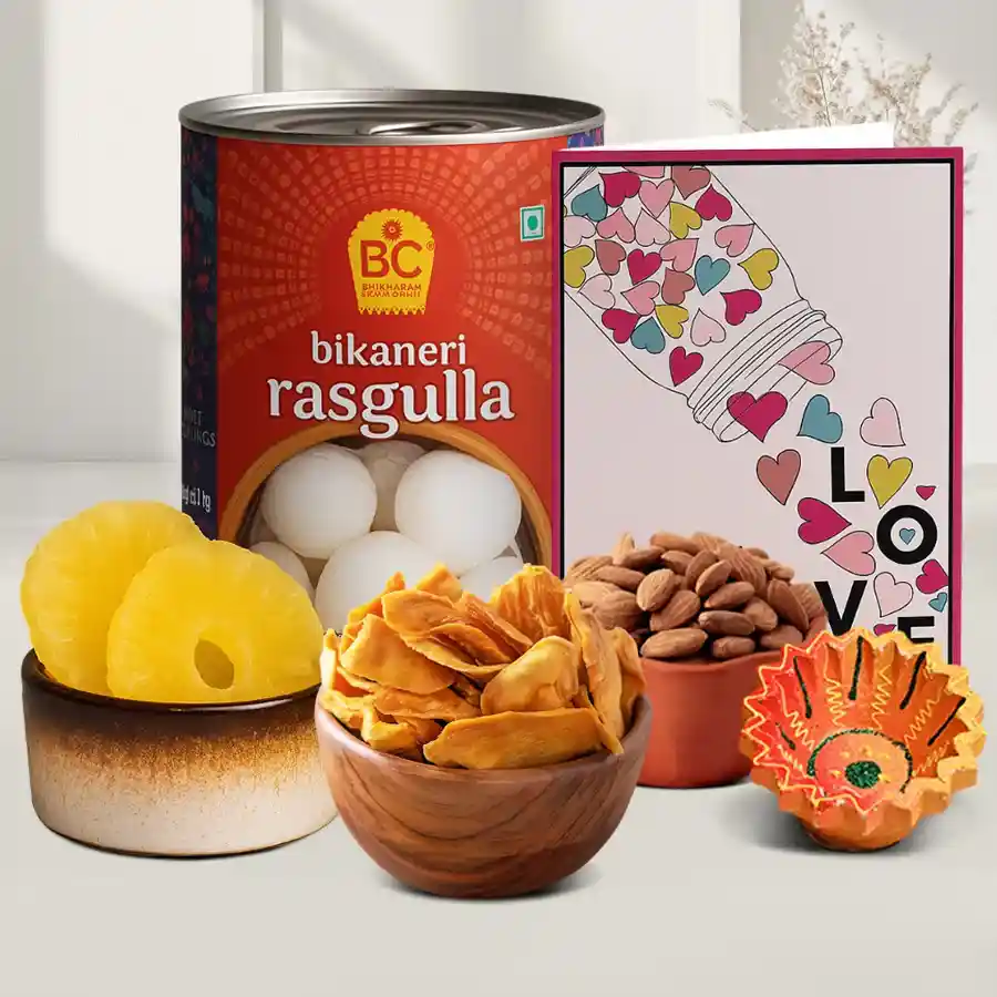 Diya, Rasgulla, and Dried Fruits Set for Diwali celebration, featuring a diya, Bhikaram Chandmal Rasgullas, dried pineapples, dried mangoes, and almonds, along with a message card.