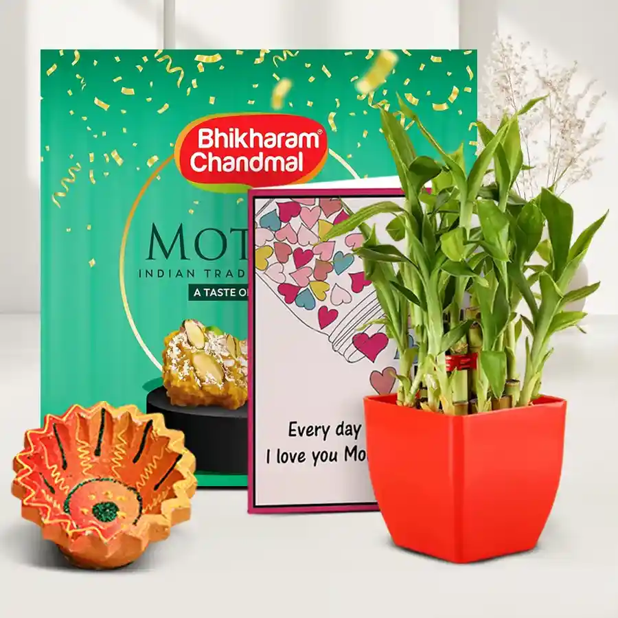 Bamboo Plant and Motipak Extravaganza hamper featuring a handcrafted diya, 500g of Motipak sweets, and a three-tier lucky bamboo plant, with a personalized message card, set against a festive backdrop.