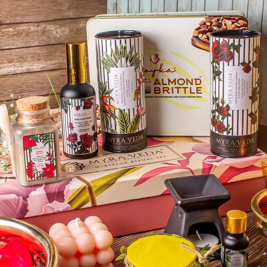 Delightful Collection of Goodies hamper featuring almond brittle chocolate, rose water, organic clay, soy wax candles, luxurious lotions, body washes, 24K gold gel, and bergamot essential oil.