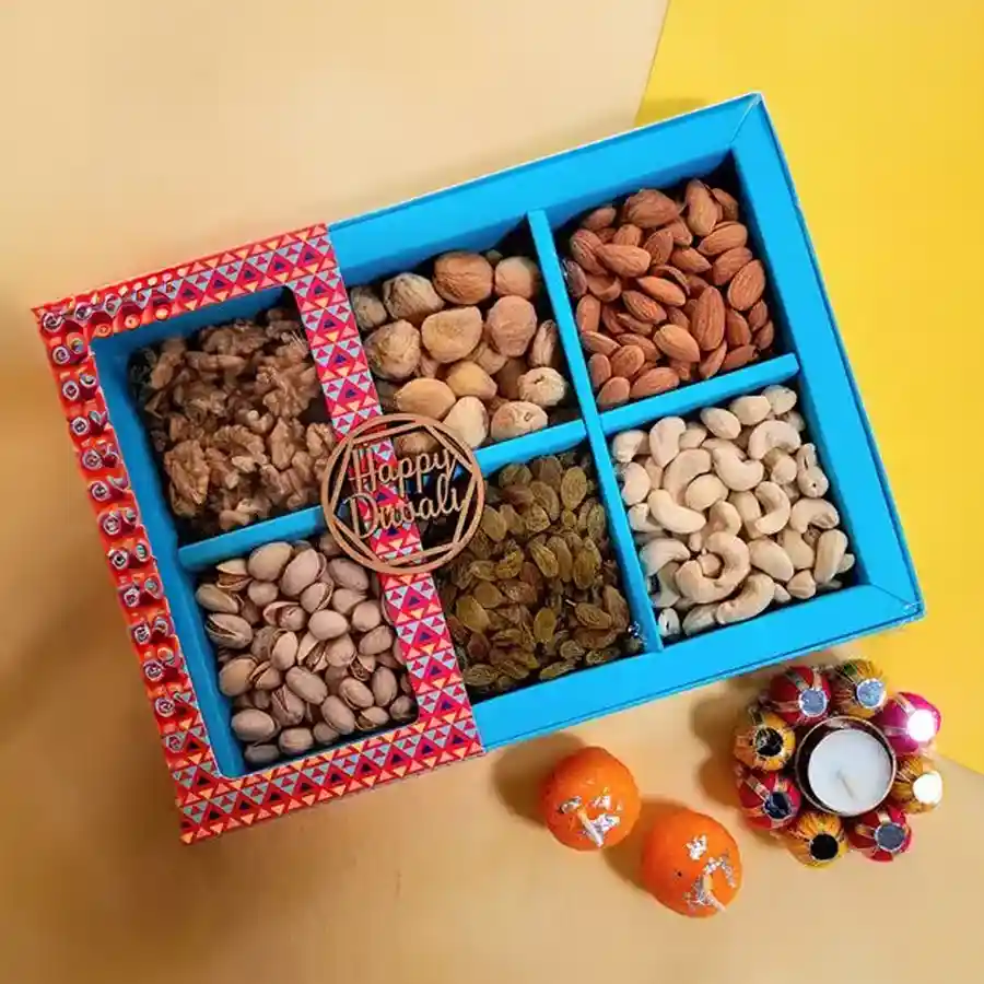 Diwali hamper featuring premium nuts, dried fruits, and decorative candles in a gift box.