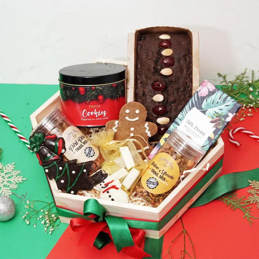 Christmas Magic Hamper featuring a variety of festive treats including Plum Cake, lollipops, Snowman, Gingerbread Men Cookies, assorted chocolates, Italian and Piri Piri Trail Mixes, Snickerdoodle Cookies, and Dark Belgian Chocolate Bar.