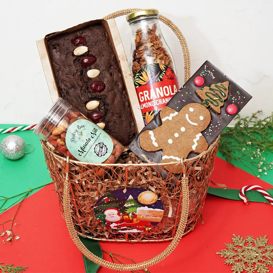 Christmas Cravings Collection hamper featuring a Plumcake, Chocolate & Cookie Bar, Cranberry Granola, and Masala Nuts arranged festively