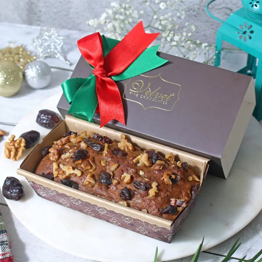A delicious sugarfree date and walnut cake on a elegant plate, surrounded by decorative elements, showcasing its moist texture and crunchy walnuts.
