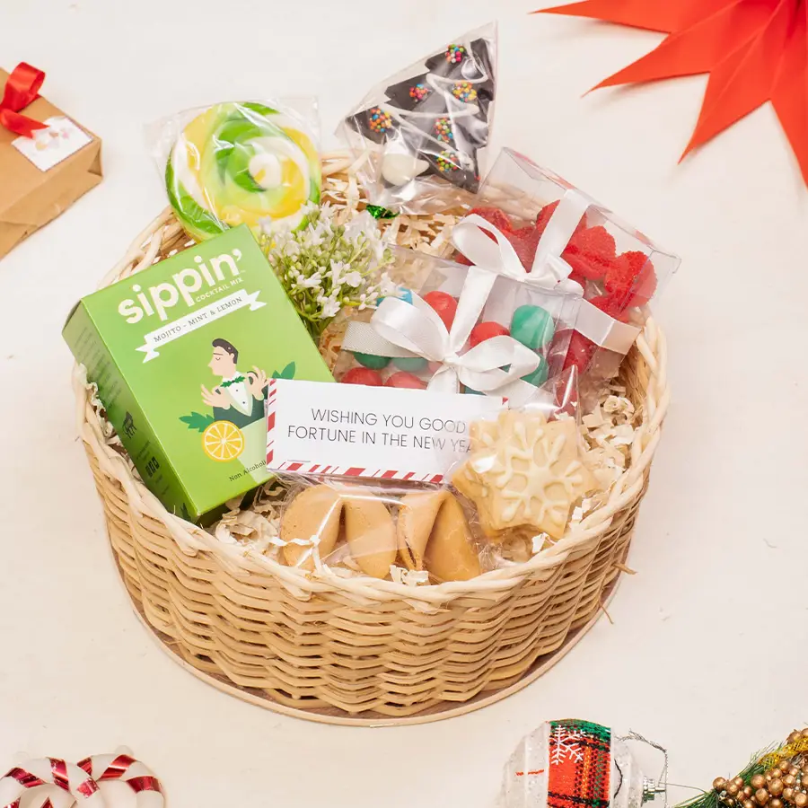 Festive Treats Gift Hamper with assorted candies, cookies, and cocktail mix arranged in a round basket