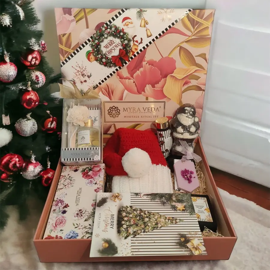 Luxurious Myraveda Reed Diffuser Gift Set featuring a reed diffuser, hand-crocheted Santa cap, Wax Bar & Soap Kit, 25KT Gold Handcrafted Soap Bar, vegan aroma soy wax with dried flowers, 3D Santa Belgian chocolates, Turkish Rose, Almond, Saffron & Milk Hand & Body Lotion, and a handwritten Christmas card.