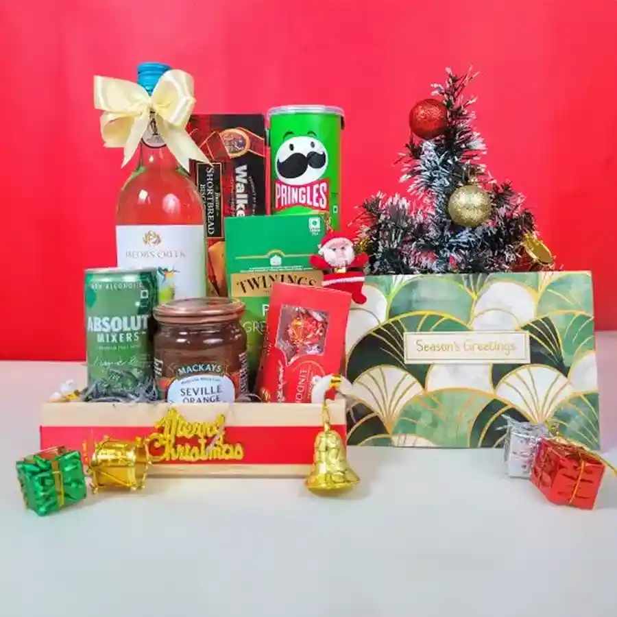 Blissful Christmas Treats Hamper filled with festive goodies including non-alcoholic Riesling, Pringles, orange marmalade, shortbread, chocolates, green tea, and mixers, elegantly gift-wrapped with a holiday card