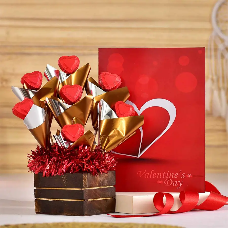 Whimsical chocolaty arrangement in a rustic wooden pot with handcrafted chocolates and a Valentine's Day card