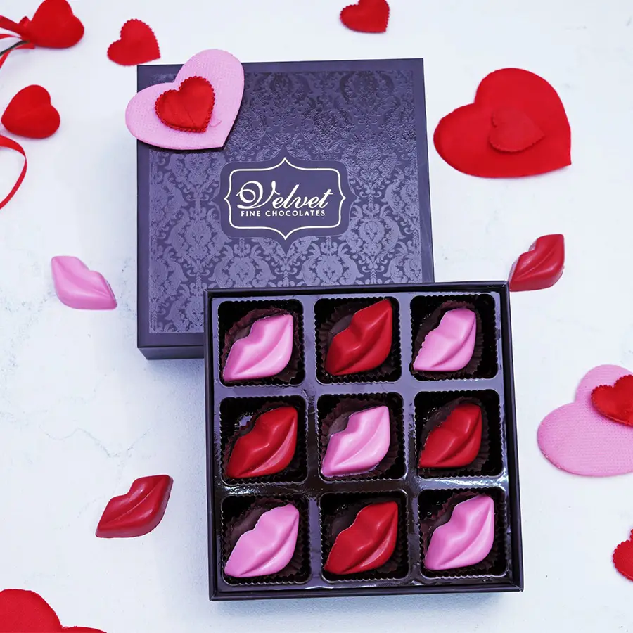 Indulgent lip-shaped chocolate gift box with nine colorful chocolates arranged inside